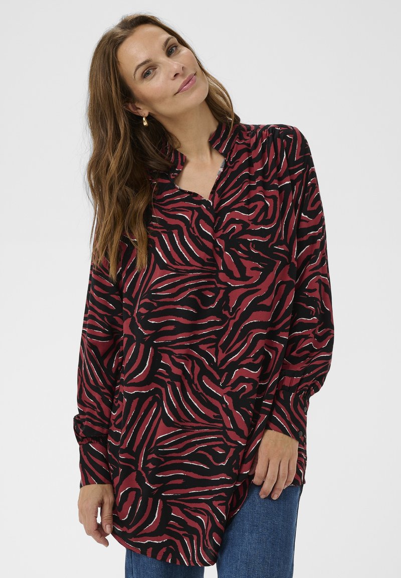 Long-sleeve shirt in red and black with a wavy zebra print, featuring a collared neckline and relaxed fit, made from a lightweight fabric.