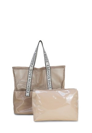Beige draagtas van gaas met witte handvatten waarop "FASHION BAGS" staat, en een glanzend beige etui met rits ervoor.