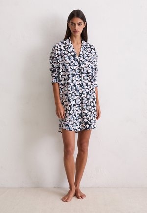 Marineblauwe bloemenjurk met lange mouwen, voorzien van een knoopsluiting aan de voorkant en een losse pasvorm. De stof heeft een zachte textuur met kleine roze bloemen.