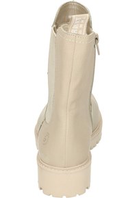 Botín de tobillo beige hecho de cuero texturizado, con cremallera lateral, paneles elásticos y una suela de goma duradera con un ligero tacón.