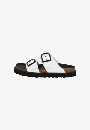 White slide sandal with two adjustable black buckles, textured cork footbed, and thick black rubber sole. Simple design, open toe.