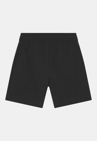 Calções de algodão pretos com um cós elástico, um design simples e um corte reto, sem padrões adicionais ou acessórios.