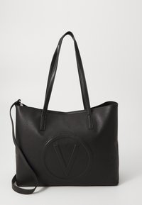 Svart konstläder totebag med två axelremmar, en avtagbar crossbody-rem och en präglad rund 'V' logotyp på framsidan.