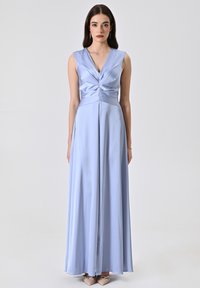 Hellblaues satin Kleid mit V-Ausschnitt und ärmellosem Design. Das Oberteil weist eine geraffte Detail auf und fließt in einen langen Rock.