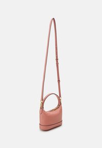 Pequeño bolso cruzado de cuero texturizado rosa con un asa superior, correa de hombro ajustable y detalles de cremallera dorada visibles.