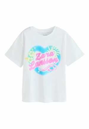 Hvid T-shirt med farverigt hjerteformet design, pink skrift "Zara Larsson", gul sol og hibiscusblomster på brystet.