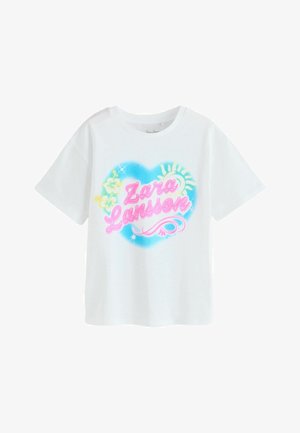 Hvid T-shirt med farverigt hjerteformet design, pink skrift "Zara Larsson", gul sol og hibiscusblomster på brystet.