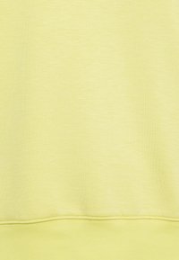 Light yellow fabric, soft texture, smooth finish, featuring a subtle sheen. Simple design with a rounded hem and minimal stitching detail.