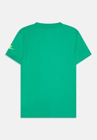 Groene katoenen T-shirt met korte mouwen. Heeft een ronde hals en een klein geel logo op de linker mouw. Soepele textuur.