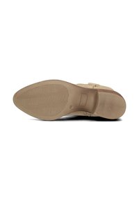 Scarpa in suede beige con punta arrotondata e suola in gomma testurizzata bassa. Presenta un cinturino alla caviglia con dettaglio con fibbia.