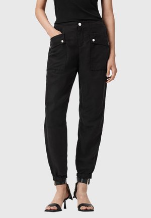 Musta rentoistukkaiset työkaluhousut, joissa on etutaskut, nepparit ja joustavat lahkeensuut. Valmistettu kevyestä kankaasta, jossa on pehmeä pinta.