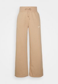 Beige sweatpants made of soft fabric, featuring a wide-leg design and elastic waistband with drawstring. Small white logo on the front.
