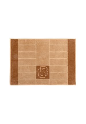 Tappeto rettangolare beige e marrone con due bordi verticali marrone scuro e una lettera B stilizzata nel disegno quadrato centrale.