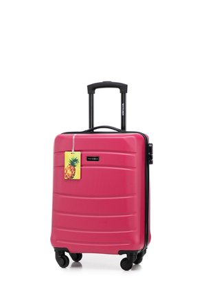 Hard-shell pink suitcase with textured surface, black zipper and handle, four swivel wheels, and a pineapple-shaped tag. Compact design.