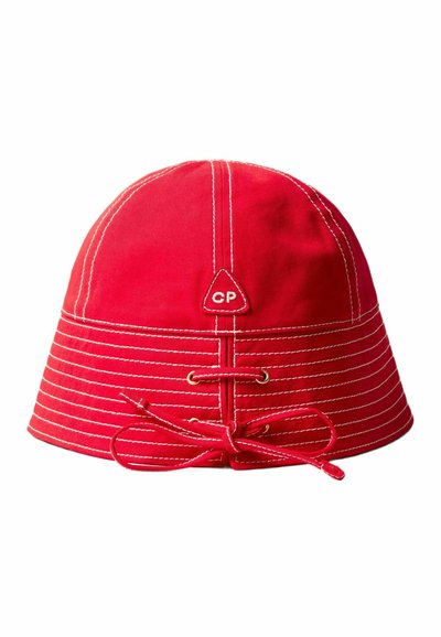 Cappello a secchiello in cotone rosso con cucitura bianca, presenta una toppa con logo triangolare, occhielli e un cordino per la regolazione.