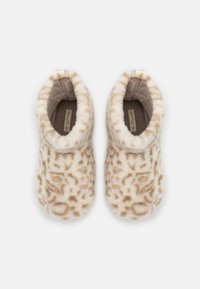Furry beige slippers with a leopard print pattern, featuring a soft texture and a rounded shape. Includes a tab for easy wear.