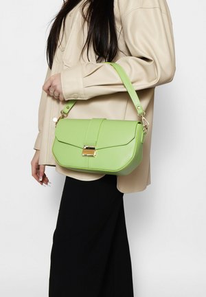 Borsa sintetica verde con chiusura a pattina, hardware dorato e un manico corto. La borsa ha una forma strutturata e una texture liscia.