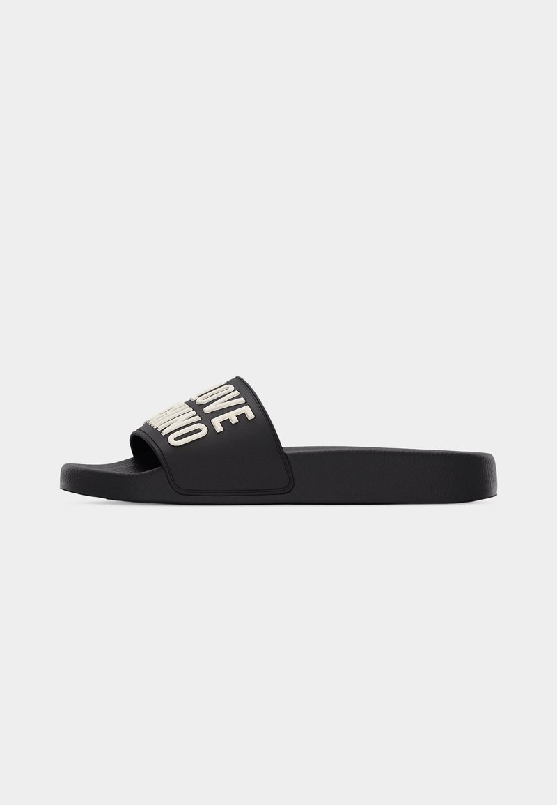 Black slide sandal with thick white raised text on the strap reading "LOVE MOSCHINO," viewed from the side on a white background.
