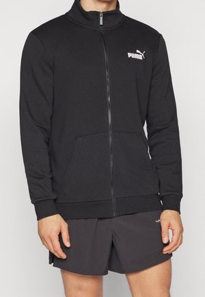 Felpa nera con zip realizzata in tessuto dalla consistenza liscia, dotata di tasche laterali e di un logo Puma bianco sul lato sinistro del petto.