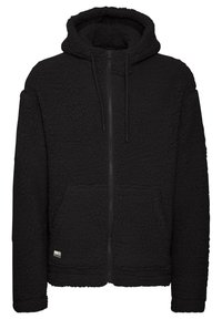 Black fleece hoodie with a textured exterior, full zip closure, front pockets, and a drawstring hood. Soft material and relaxed fit.