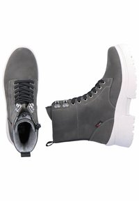 Botas de tobillo de cuero gris con suela de goma blanca, cordones negros, ojales de metal y cierre con cremallera en el lateral para facilitar su uso.