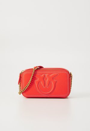 Lille rød crossbody taske i læder med kæderem, med præget logo og kontrastsyninger, rektangulær form, tekstureret overflade.