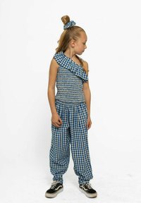 Kék és fehér kockás öltözet, egy vállas, fodros felsővel, smockolt melltartóval és laza szabású kockás nadrággal. Tartalmaz egy illeszkedő hajgumit is.