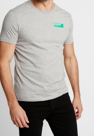 Grå kortærmet t-shirt lavet af bomuldsblanding. Har et lille grønt mærke med teksten "UNITED COLORS OF BENETTON" i hvidt.