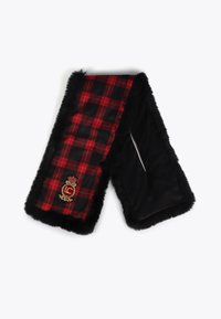 Rutet tørklæde med rødt, sort og hvidt mønster, trimmet med sort faux pels. Har et broderet emblem med gyldne detaljer.