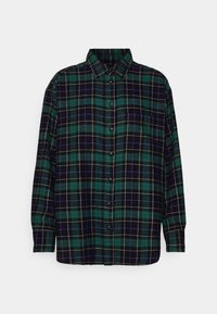 Chemise à carreaux vert foncé et bleu marine, avec des accents blancs. Modèle boutonné avec un col classique et des manches longues. Texture de tissu douce.