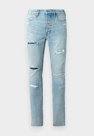 Hellblaue Jeans im Slim Fit mit mehreren abgerissenen Stellen, klassischem Fünf-Taschen-Design und dezentem Verblassen.