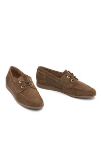 Scarpe in suede marroni con profilo basso, design stringato e dettagli in metallo dorato. Presentano una punta chiusa e cuciture lungo i bordi.