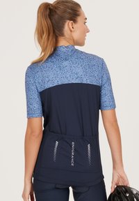 Maillot de cyclisme bleu marine avec une partie supérieure à motif bleu, des manches courtes, un col haut et une poche élastique arrière marquée "ENDURANCE."