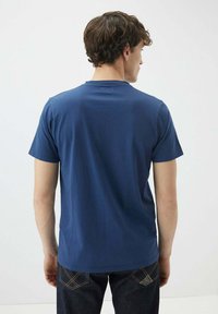T-shirt blu navy a maniche corte con scollatura tonda, realizzato in cotone, caratterizzato da una superficie liscia e una vestibilità rilassata. La vista posteriore mostra un design semplice.