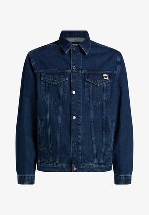 Chaqueta de denim azul oscuro con un collar clásico, cierre de botones en la parte frontal, dos bolsillos en el pecho y un pequeño pin de logo en el bolsillo izquierdo.