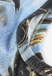 Close-up of a ribbed fabric neckline with detailed stitching, showing a multicolored abstract pattern on soft textured material.