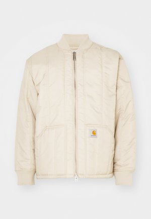 Světle béžová bomber bunda s předním zipem, žebrovaným límcem a manžetami, dvěma kapsami a vertikálními stehy. Logo Carhartt na kapse.