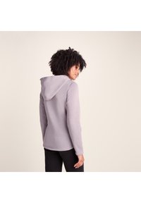 Gray hooded sweatshirt with a textured finish, featuring a relaxed fit, long sleeves, and a soft fabric. Back view shows hooded design.