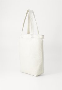Leinen-Umhängetasche in Off-White mit langen, flachen Trageriemen. Verfügt über sichtbare Nähte und hat eine rechteckige Form mit einem stabilen Boden.