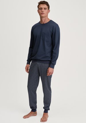 Navy long-sleeve shirt with a pocket, paired with patterned navy pajama pants featuring a swirling design in light blue and red accents.
