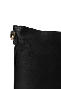 Bolso de cuero negro con un acabado texturizado, que presenta un anillo de metal dorado en un lado. Diseño simple y minimalista.