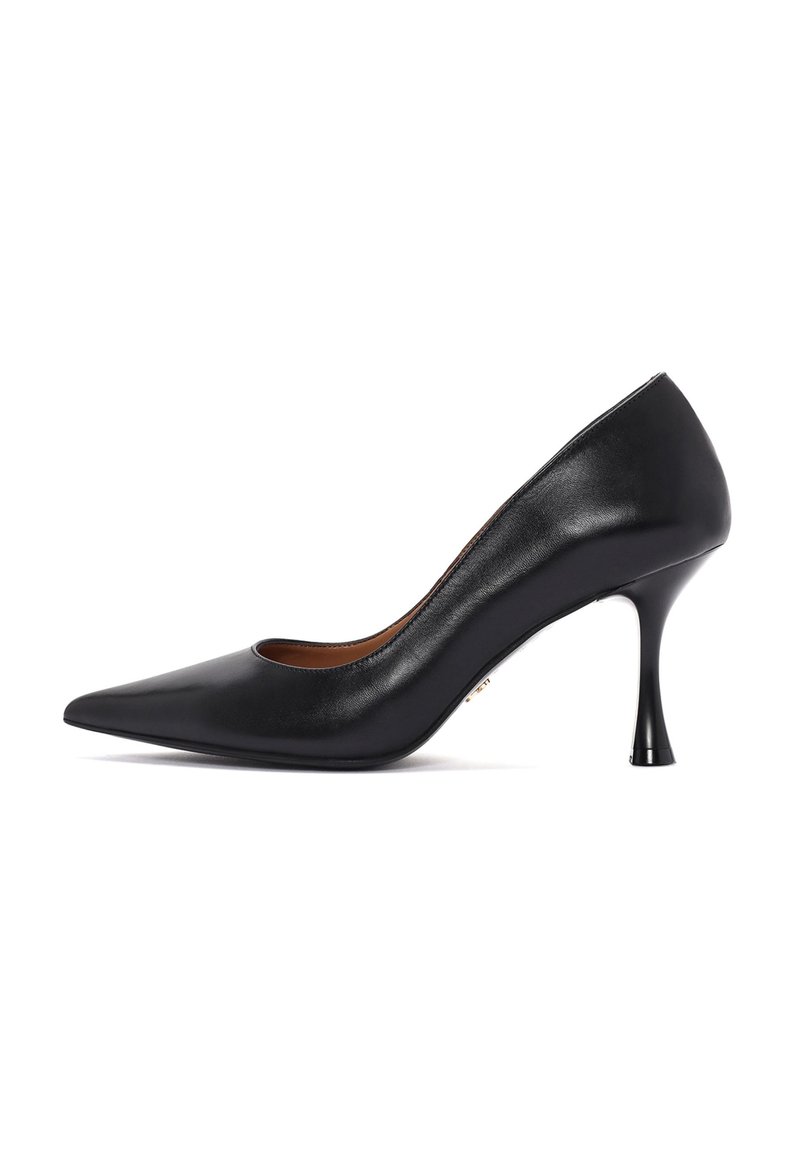 Zapato de tacón negro de cuero con punta afilada y un tacón curvado y estrecho. El zapato presenta una textura suave y un diseño minimalista.