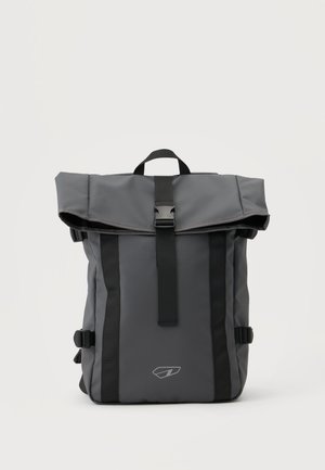 Sac à dos à rouleau gris foncé avec bretelles noires, fermeture à boucle frontale, et petit logo réfléchissant centré près du bas.