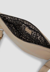 Borsa beige realizzata in pelle testurizzata, con una fodera a stampa leopardata. Presenta una chiusura con zip e una tracolla regolabile. L'interno ha più tasche.