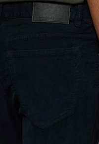 Marine corduroybroek met een gestructureerd oppervlak, voorzien van een achterzak en een rechthoekige zwarte leren patch met het reliëflogo "TRUSSARDI".
