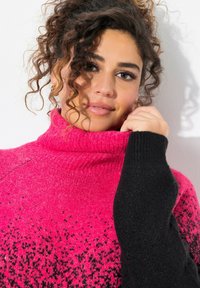 Maglione a collo alto rosa e nero con texture a maglia, design sfumato e vestibilità aderente. Collo a coste e maniche a contrasto.