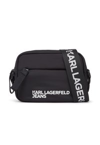 Geantă crossbody neagră din material durabil, cu buzunar frontal cu fermoar. Dispune de o curea largă reglabilă cu inscripția „KARL LAGERFELD”.