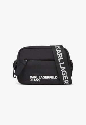 Geantă crossbody neagră din material durabil, cu buzunar frontal cu fermoar. Dispune de o curea largă reglabilă cu inscripția „KARL LAGERFELD”.