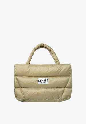 Puffer tote bag in beige, featuring a quilted design, top handles, and a visible logo patch. Smooth, padded texture throughout.