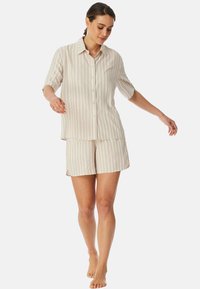 Lekkie, pasek loungewear w kolorze beżowym i kremowym, zawierające koszulę z krótkim rękawem na guziki i dopasowane szorty, o luźnym kroju.